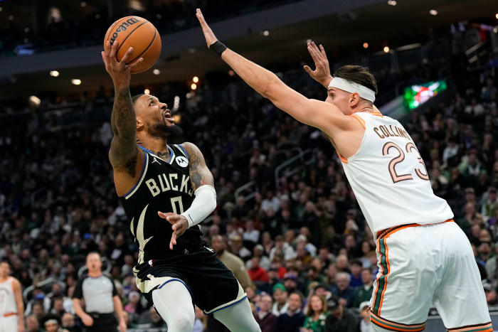 Dec 19, 2023; Milwaukee, Wisconsin, USA; Milwaukee Bucks guard Damian Lillard (0) shoots around San Antonio Spurs center Zach Collins (23) during the first quarter at Fiserv Forum.